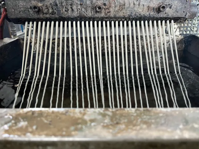 Material plástico fundido saliendo de una línea de extrusión